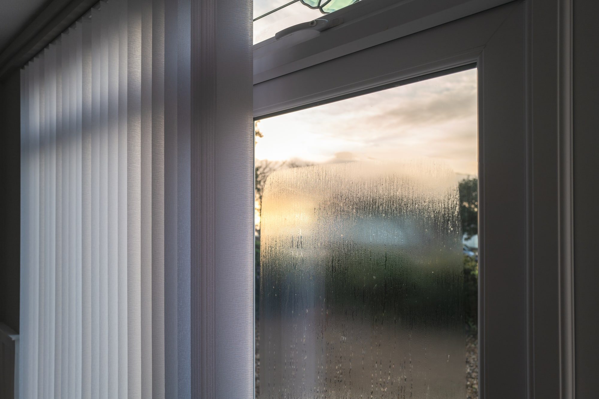 inside view of a window with condensation on the outside of double glazing