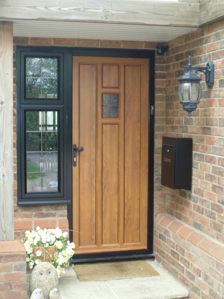 black powder coated aluminium windows & entrance door in wood effect aluminium to create the traditional design.