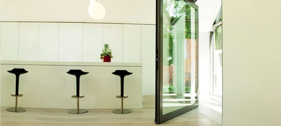 reynaers masterline 8 pivot door in a contemporary room opening to the patio