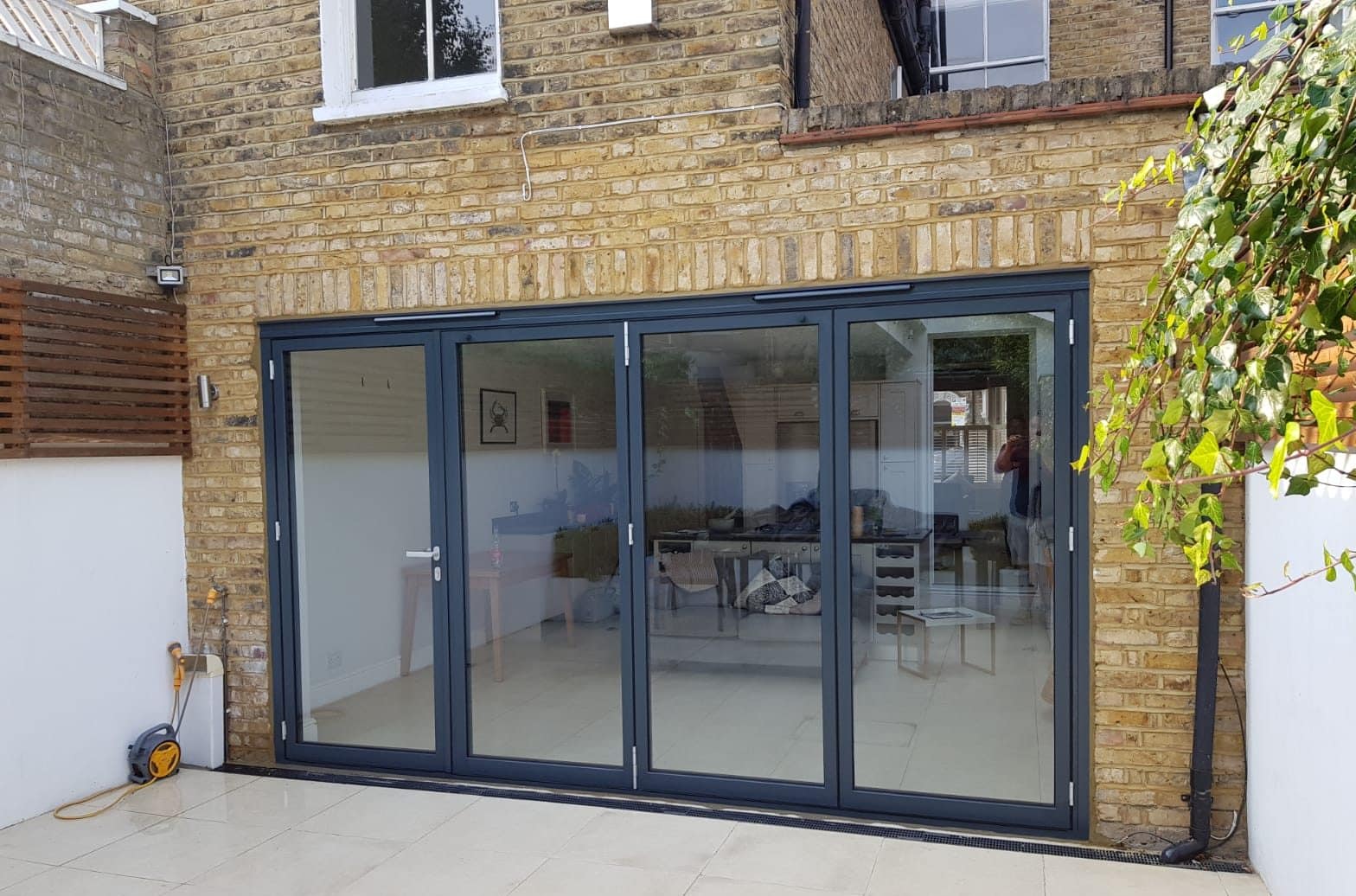 schuco bifolding doors fitted to a london terraced house in a grey colour