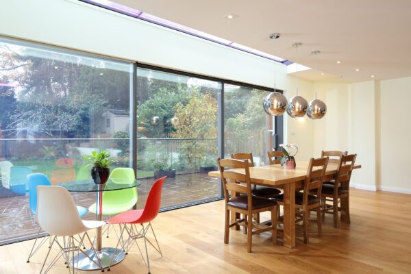 reynaers sliding doors in a house extension with wood table and floors, showing sl68 model