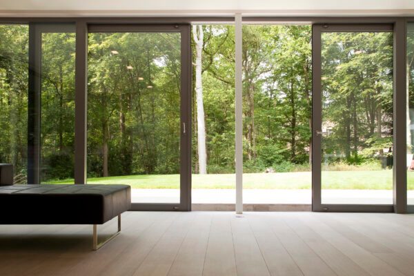 reynaers cp155 sliding doors in a modern house with forest views. 