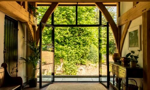 steel look french doors in the art-deco style fully open leading to a path