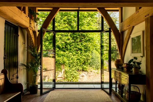 steel look french doors in the art-deco style fully open leading to a path