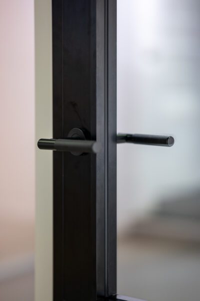 close up of black internal door handle and glass.