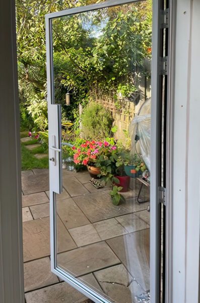 white patio door in a white colour leading to a wet patio