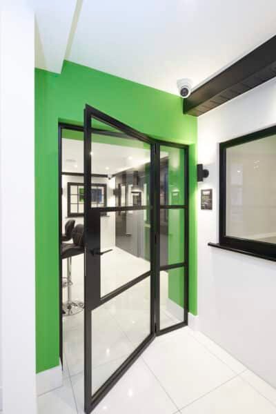 internal aluspace steel look doors in black with green surround wall and modern floor tiles. 