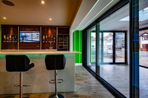 grey cortizo sliding door in a three pane design with modern floor showroom location and customer bar 